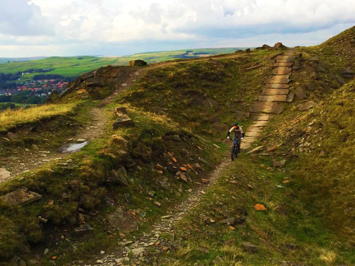 Image of child on a mounain bike coming down a dirt path for Lee Quarry Trial Centre page on Visit Rossendale website